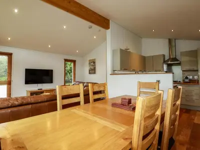 a kitchen and dining room with a wooden table and chairs at 1 Hedgerows in Looe