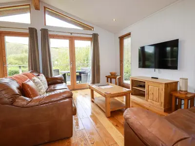 a living room with a couch and a flat screen tv at 1 Hedgerows in Looe