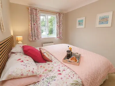 a bedroom with a bed with a tray on it at Jaspers Retreat, formerly known as Starfish Cottage in Falmouth