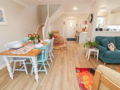a dining room and living room with a table and chairs at Jaspers Retreat, formerly known as Starfish Cottage in Falmouth