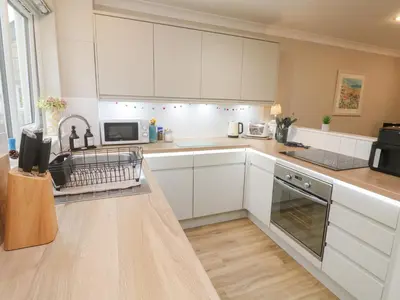 a kitchen with white cabinets and a counter top at Jaspers Retreat, formerly known as Starfish Cottage in Falmouth