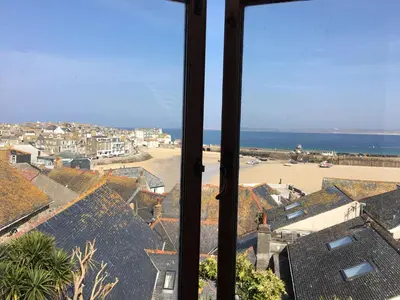 a view from a window of a town with the ocean at Admiral Cottage in St Ives