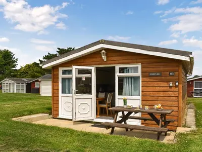 a wooden shed with a picnic table in a yard at Boobys Bay - Uk47554 in St Merryn