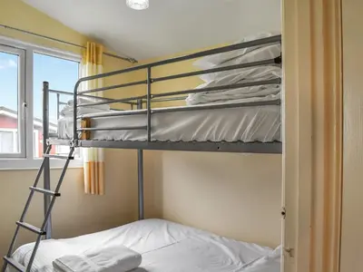 a bedroom with bunk beds in a room with a window at Boobys Bay - Uk47554 in St Merryn