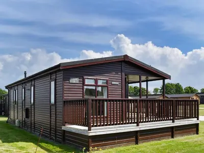 a large wooden cabin with a large deck at Stepper Point - Uk47568 in St Merryn