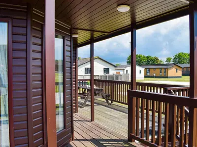 a wooden deck with a view of a picnic table at Stepper Point - Uk47568 in St Merryn