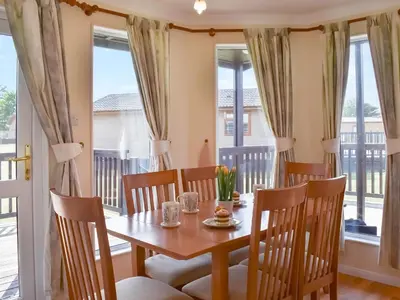 a dining room with a table and chairs and windows at Stepper Point - Uk47568 in St Merryn