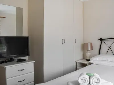 a bedroom with a bed with a television and towels at Stepper Point - Uk47568 in St Merryn