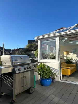a grill sitting on a deck next to a patio at Newquay Fistral Holiday home with hot tub in Newquay