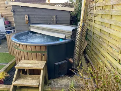 a hot tub with a bench in a backyard at Newquay Fistral Holiday home with hot tub in Newquay