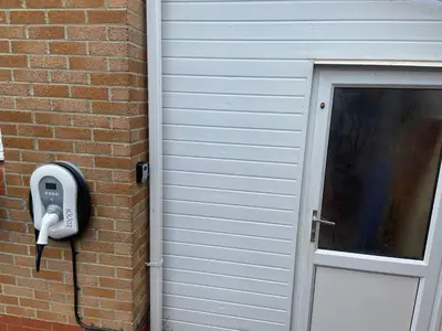 a phone on the side of a brick wall next to a door at Newquay Fistral Holiday home with hot tub in Newquay