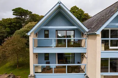 a blue house with a balcony at Clowance, Golf View 80b in Praze an Beeble
