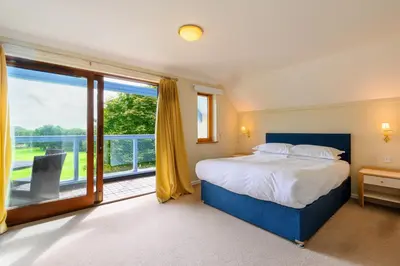 a bedroom with a bed and a large window at Clowance, Golf View 80b in Praze an Beeble