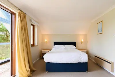 a bedroom with a bed and a large window at Clowance, Golf View 80b in Praze an Beeble