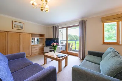 a living room with two blue couches and a table at Clowance, Golf View 80b in Praze an Beeble