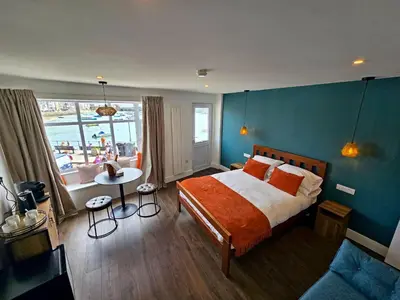a bedroom with a bed and a blue wall at Premier 2 - Stunning Suite with Breathtaking Seaside Views in St Ives