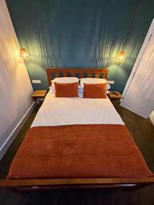 a bedroom with a large bed with orange pillows at Premier 2 - Stunning Suite with Breathtaking Seaside Views in St Ives