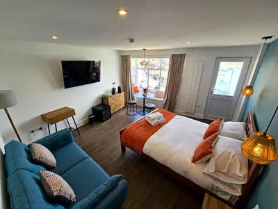 a bedroom with a bed and a blue couch at Premier 2 - Stunning Suite with Breathtaking Seaside Views in St Ives