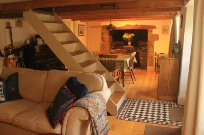 a living room with a couch and a spiral staircase at Tranquil Cornish Heritage Retreat in Falmouth