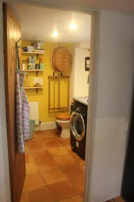 a bathroom with a toilet and a washing machine at Tranquil Cornish Heritage Retreat in Falmouth