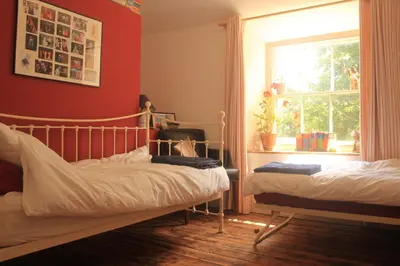 a bedroom with two beds and a window at Tranquil Cornish Heritage Retreat in Falmouth