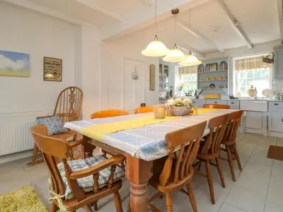 a kitchen and dining room with a table and chairs at Connie's Cottage in Helston