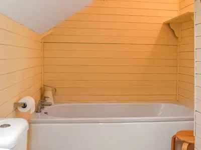 a bathroom with a tub and a toilet and a sink at Trethvor in Perranporth