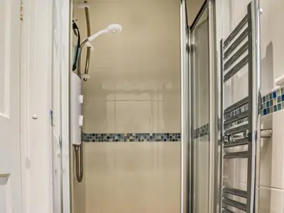 a shower with a glass door in a bathroom at Trethvor in Perranporth