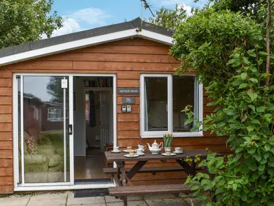 a picnic table in front of a tiny house at Gunner Head - Uk47557 in St Merryn
