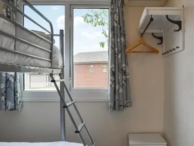a bedroom with a ladder next to a window at Gunner Head - Uk47557 in St Merryn