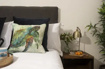 a bed with a pillow with a lizard on it at Landing View Fowey Penthouse in Fowey