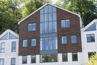 an external view of a building with glass windows at Landing View Fowey Penthouse in Fowey