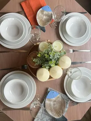 a table with white plates and a bowl of flowers at Cornwall caravan in Crantock