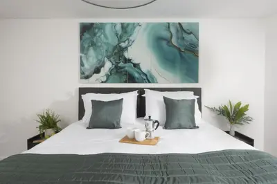 a bed with a tray with two mugs on it at Sea Breeze, Newquay in Newquay