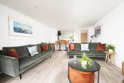 a living room with two couches and a table at Sea Breeze, Newquay in Newquay