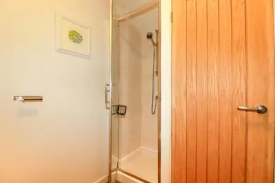 a shower with a glass door in a bathroom at 3 Lake View in Looe