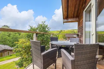 a patio with a table and chairs on a balcony at 3 Lake View in Looe