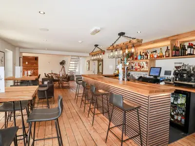 a bar in a restaurant with tables and chairs at 3 Lake View in Looe