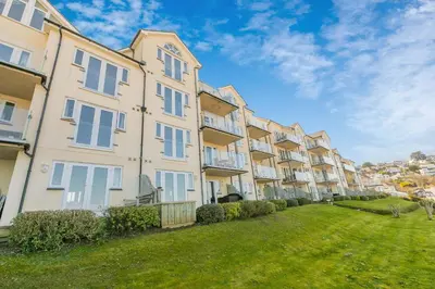 a row of apartment buildings with a green yard at Viridian in Carbis Bay