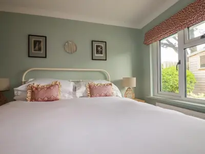 a bedroom with a white bed and a window at 6 Trelawney Court in Wadebridge