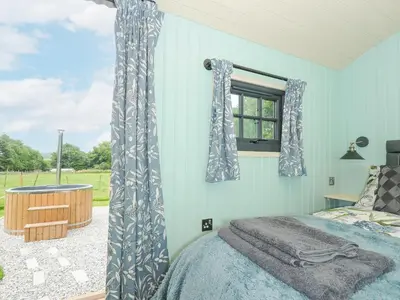 a bedroom with a bed and a window at Bracken in Bude