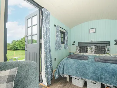 a bedroom with a bed and a window at Bracken in Bude