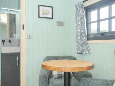 a room with a table and a chair and a window at Bracken in Bude
