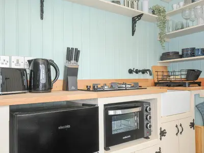 a kitchen with a stove and a microwave at Bracken in Bude