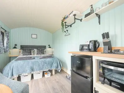 a bedroom with a bed in a room with blue walls at Bracken in Bude