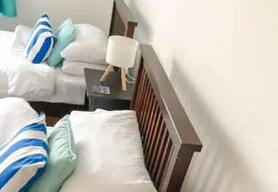 a bedroom with two beds and a table with a lamp at Birdsong in Carbis Bay