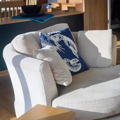a white couch with pillows on it in a living room at Birdsong in Carbis Bay