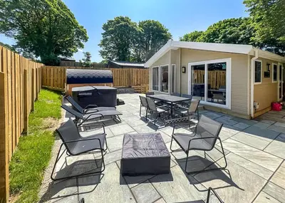 a patio with a group of chairs and a table at Hamlet Lodge Retreat At Calloose Holiday Park in Hayle