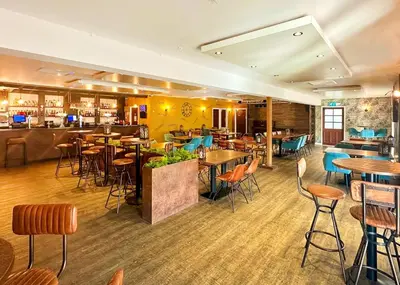 a restaurant with tables and chairs and a bar at Calloose Holiday Park in Hayle