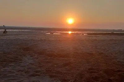 a sunset on a beach with the sun setting at Sunny holiday house in Newquay
